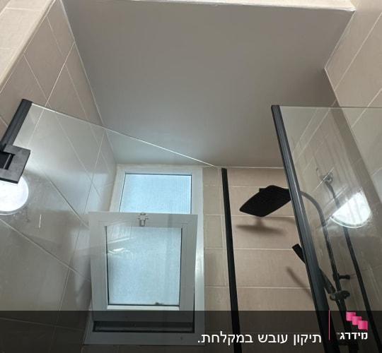 מקלחת עם דלת זכוכית וברז שחור